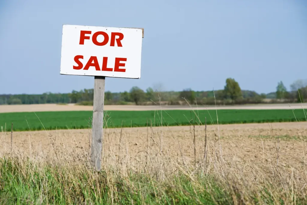 A sign is in front of the agricultural field representing selling inherited property with siblings